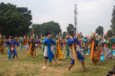 Group of people in field against sky