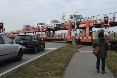 Rear view of man standing on road against sky