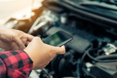 Midsection of man holding mobile phone