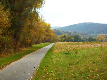 Empty road amidst landscape against clear sky