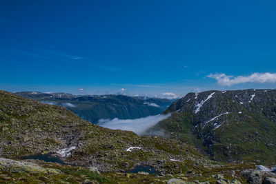 Scenic view of mountains against blue sky