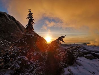 Scenic view of rock against sky during sunset