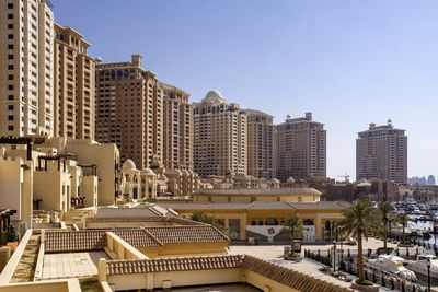Buildings in city against clear sky