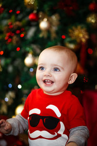 Portrait of cute baby boy with christmas tree