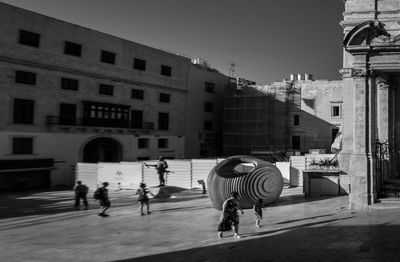 Rear view of people walking on street in city