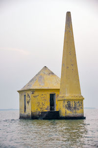 Built structure by sea against clear sky