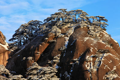 Low angle view of rocky mountain against sky