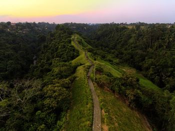 Aerial view of dirt road on mountain against sky during sunset