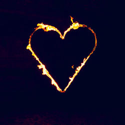 Close-up of heart shape decoration against sky at night