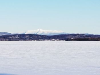 Scenic view of lake and mountains against clear sky