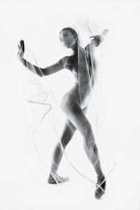 Woman wrapped in textile while dancing against white background