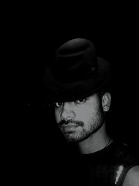 Close-up portrait of young man against black background