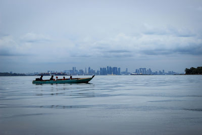 Boat in sea against cloudy sky