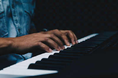 Midsection of man playing piano