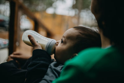 Portrait of boy holding drink drinking water