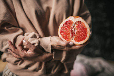 Midsection of woman holding strawberry