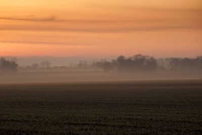 Scenic view of field against sky during sunset