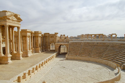 View of ruins of building against cloudy sky