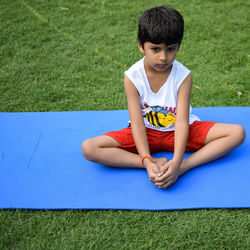 Asian smart kid doing yoga pose in the society park outdoor, children's yoga pose. the little boy