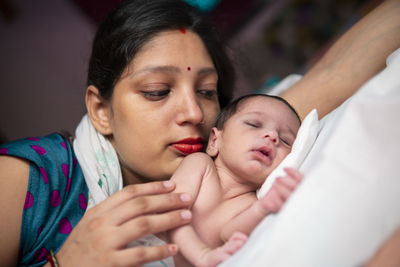 Close-up of mother carrying daughter at home