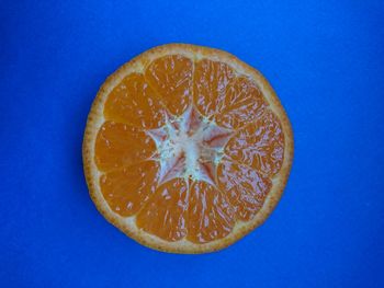 Close-up of orange slice against blue background