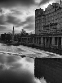 Bridge over river against buildings in city