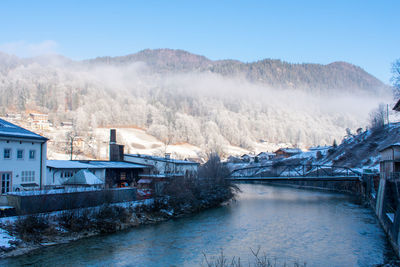 River amidst buildings against sky during winter