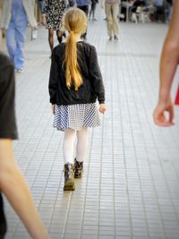 Rear view of women walking on zebra crossing