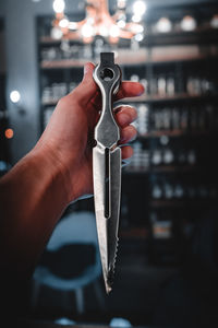 Cropped hand of person holding knife at home