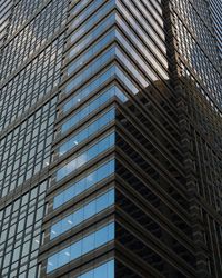 Low angle view of modern glass building in city