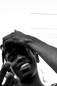 Portrait of smiling young man against sky