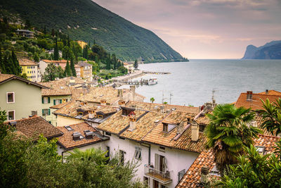 High angle view of houses by sea against sky