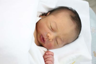 Close-up of baby sleeping in bed