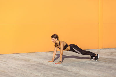 Woman sitting on floor against wall