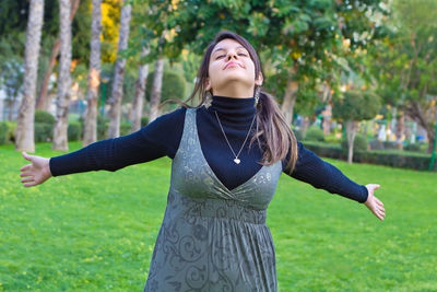 Beautiful young woman standing on field