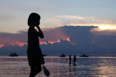 Girl by girl with young woman and boats at dusk