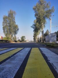 Empty road against clear blue sky