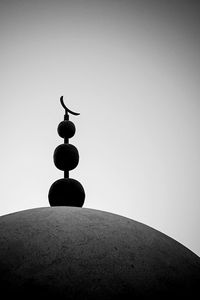 Low angle view of silhouette bird on rock against sky