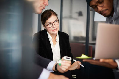 Male entrepreneur giving presentation to bank managers during meeting in creative office