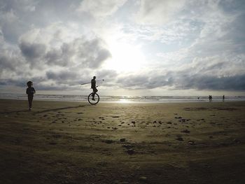 People on beach against sky