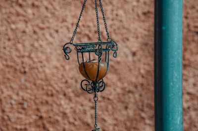 Close-up of lantern hanging against textured wall