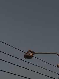 Low angle view of power lines against clear sky