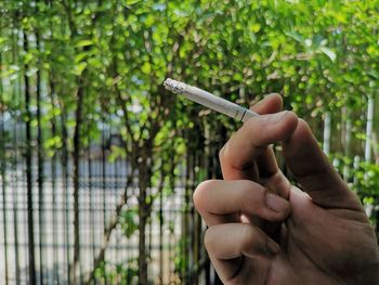 Close-up of hand holding cigarette