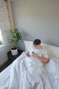 Portrait of woman sitting on bed at home