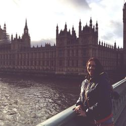 Mid adult woman in front of clock tower in city