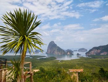 Scenic view of sea by mountains against sky