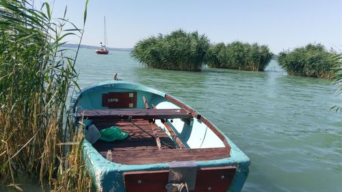 Boat moored in lake against sky