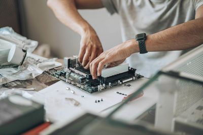 Component, hands meticulously assembling desktop motherboard, technology, manual expertise