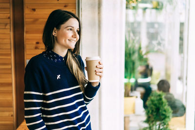 Mid adult woman holding coffee cup