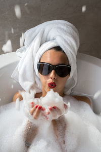 Woman blowing foam in the bathtub